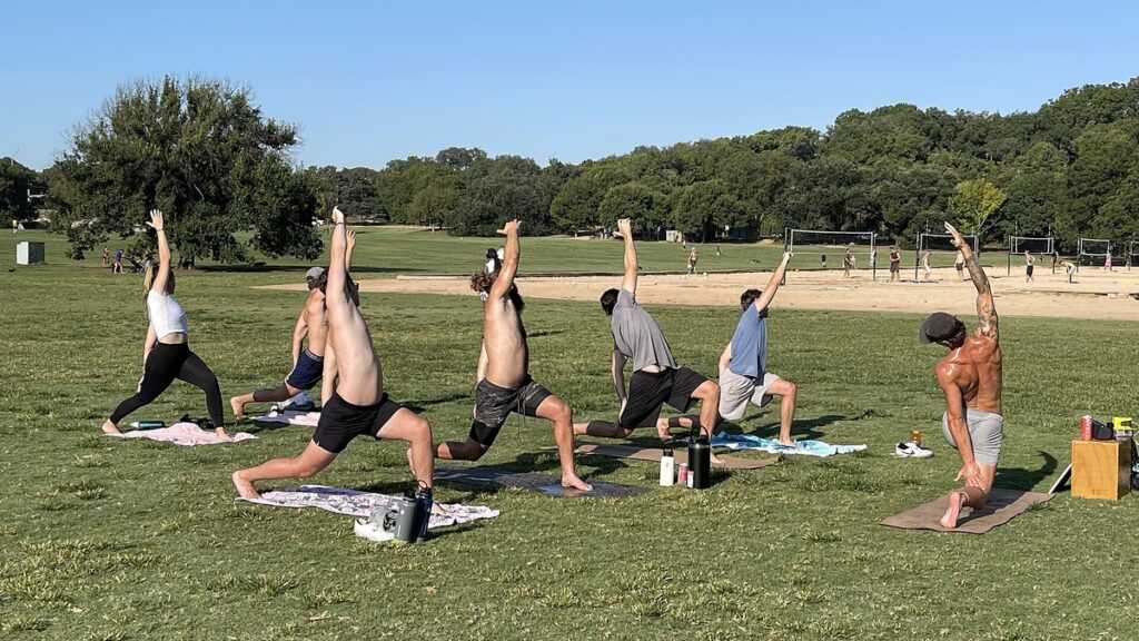 Groupe en pratique de yoga douce dans un parc, pour illustrer une pause respiratoire face au stress