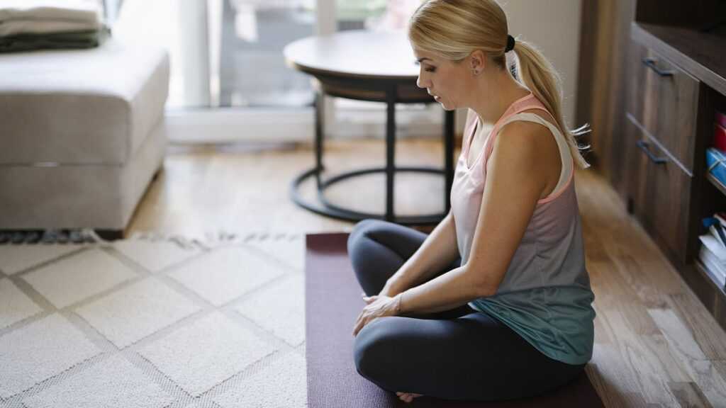 Pratique de yoga assise dans un intérieur calme, pour illustrer l’attention au souffle et aux sensations